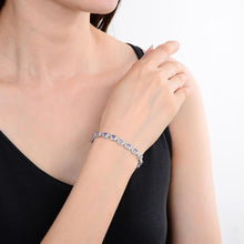 Load image into Gallery viewer, Elegant model hand showcasing the intricate details of our silver bracelet Sterling Silver Oval Tanzanite Bracelet