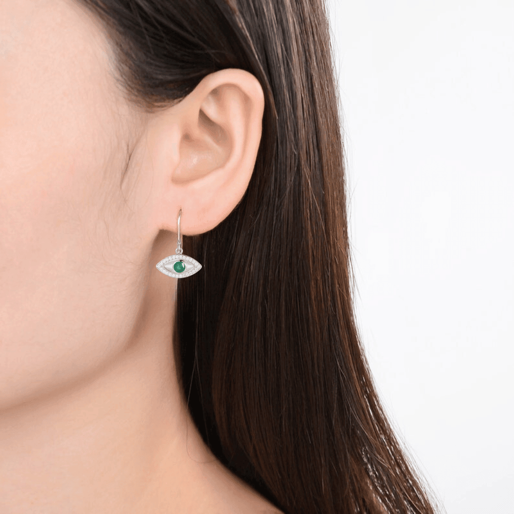 model showcasing emerald earring evil eye earrings	emerald evil eye	mal de ojo earrings	green eye earrings silver evil eye dangling evil eye	dangling earrings	protection earrings evil eye charm silver earrings may birthstone