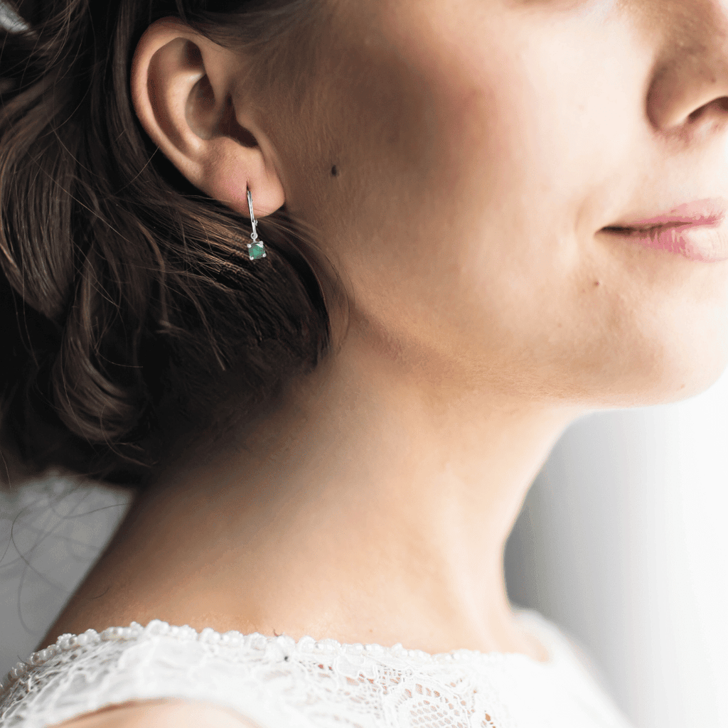 model showcasing emerald earrings silver earrings hoop earrings emerald hoops rhodium earrings green stone earrings dainty emerald green emerald dainty hoop earrings cute hoop earrings silver hoop earrings may birthstone half hoops